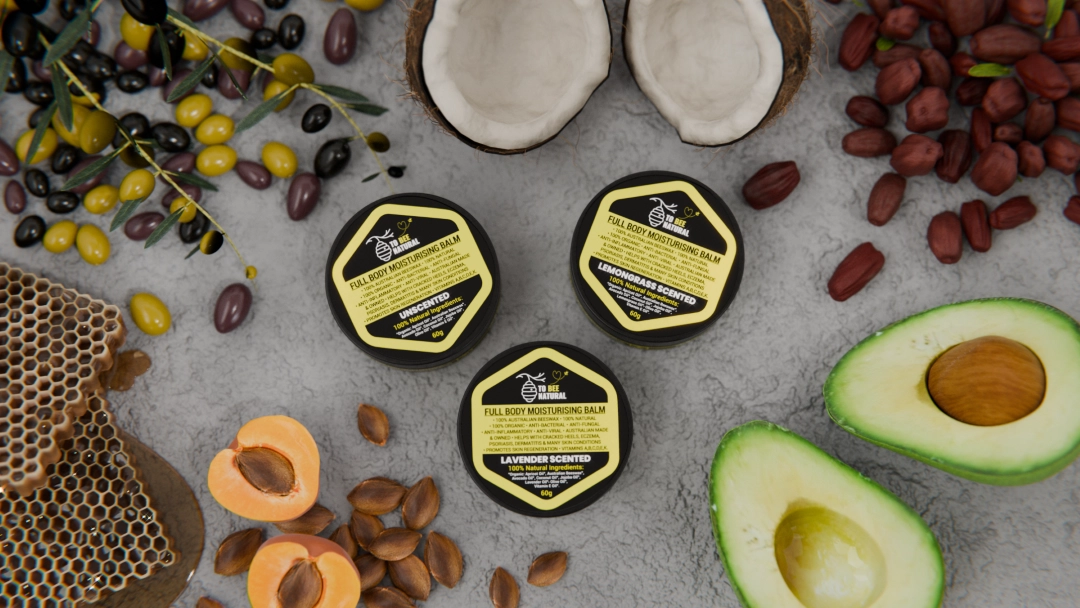 product render of a body butter tub surrounded by fruit olives and honey